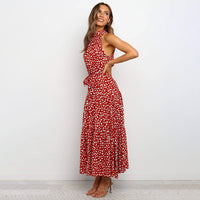 Frau in rotem, gepunktetem Maxikleid, ärmellos, mit Schleife, elegant, modisch.