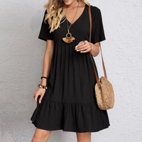 Frau in schwarzem Sommerkleid mit Strohtasche, modisches Outfit, Freizeitkleidung.