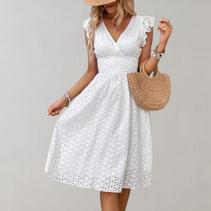Frau in weißem Sommerkleid mit Strohhut und Tasche, Spitzenmuster, modisch, elegant.