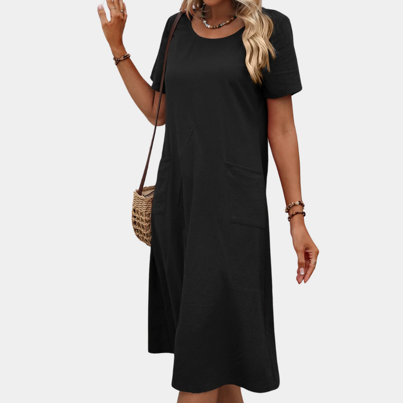 Frau in schwarzem Sommerkleid mit kurzen Ärmeln und Strohtasche, lässige Mode.