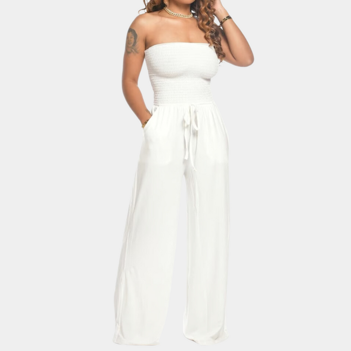 Frau in weißem, schulterfreiem Jumpsuit, elegant, Sommermode, Damenbekleidung, Freizeitlook.