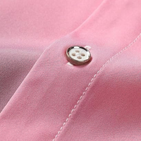 Rosa Hemd aus Baumwolle mit Knopfdetail, Nahaufnahme, elegante Mode, hochwertige Verarbeitung.