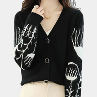 Frau trägt schwarzen Cardigan mit Blumenmuster, V-Ausschnitt, Knöpfen, modisch, elegant.