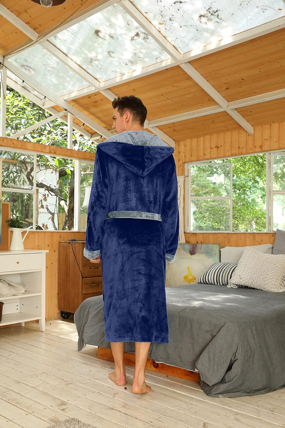 Rückansicht des marineblauen Bademantels mit grauem Kapuzenfutter, getragen in einem Schlafzimmer mit Holzwänden 44