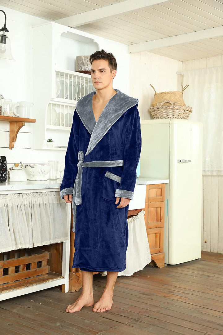 Mann im marineblauen Bademantel mit grauem Revers steht in einer hellen Küche neben einem Retro-Kühlschrank 45