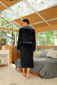 Rückansicht des schwarzen Kapuzenbademantels mit grauem Gürtel, getragen in einem Holzraum mit Bett 6