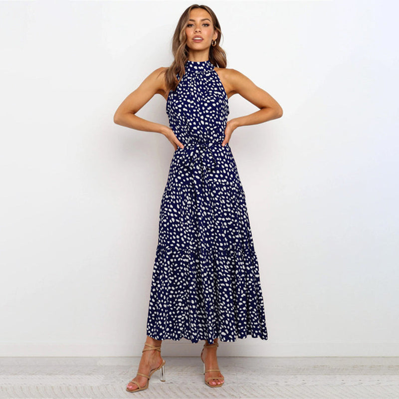Frau in eleganter, langärmeliger, blauer Maxikleid mit weißen Punkten, modisch, stilvoll.