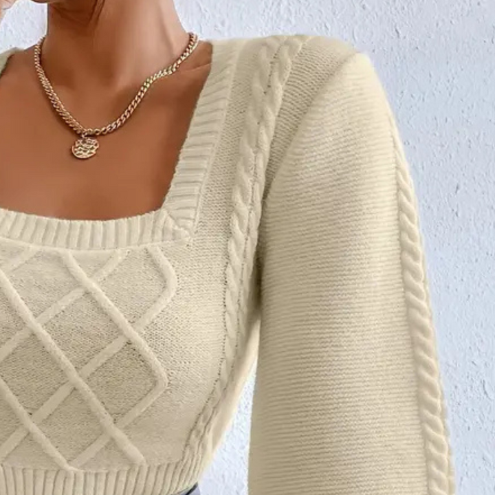 Beigefarbener Strickpullover mit Zopfmuster, quadratischem Ausschnitt und langen Ärmeln.