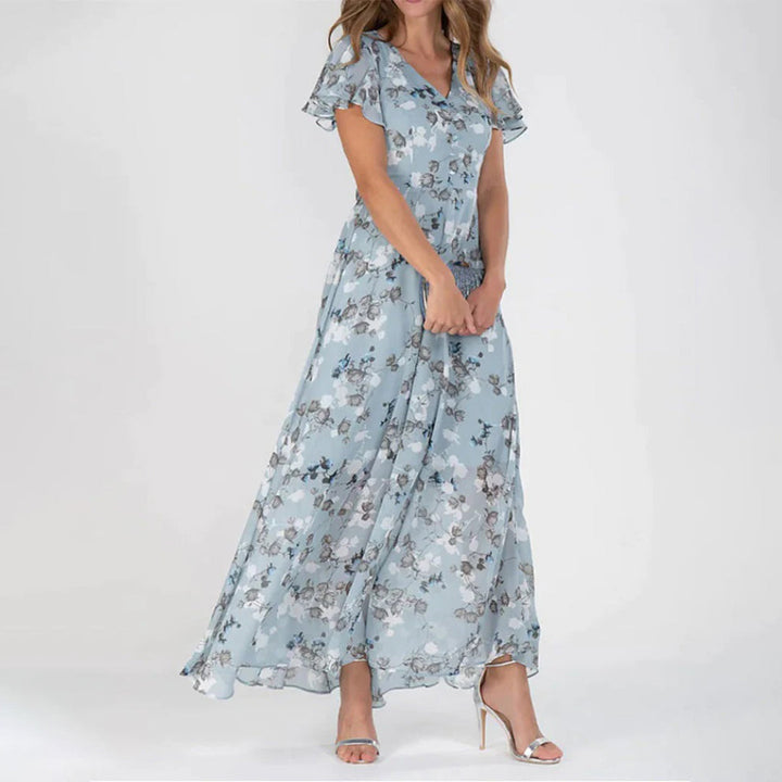 Frau in blauer, geblümter Maxikleid aus Chiffon, elegant, sommerlich, modisch.