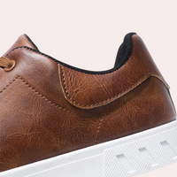 Dunkelbrauner Ledersneaker mit weißer Sohle, Herrenschuh, modisch, bequem, hochwertig.