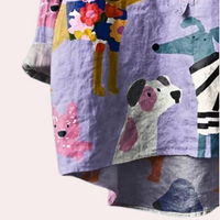 Buntes Kinderhemd mit Tiermotiven, lila Hintergrund, Baumwolle, kurzärmelig.