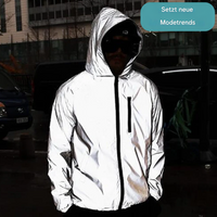 Nahaufnahme eines Models mit Kapuze und dunkler Brille in der reflektierenden Jacke vor Gebäuden und geparkten Autos 7