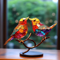 Zwei einander zugewandte Vögel in Orange, Rot und Violett auf einem geschwungenen Zweig mit schwarzer Standfläche 4