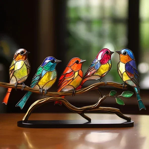 Fünf farbenfrohe Vögel sitzen nebeneinander auf einem bronzefarbenen Metallast mit grünen Blättern auf schwarzem Sockel 2