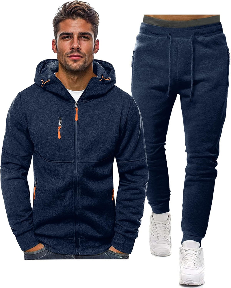 Marineblaue Kapuzenjacke mit Reißverschluss und orangen Zippern, daneben die passende Jogginghose mit Kordelzug, vor weißem 1