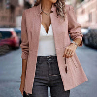 Frau in rosa Blazer, weißem Top und Jeans auf Straße, modisch, elegant, Herbstmode.