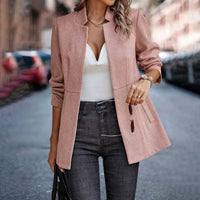 Frau in rosa Blazer, weißem Top und Jeans auf Straße, modisch, elegant, urbaner Stil.
