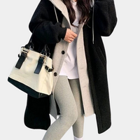 Frau in schwarzem Wollmantel mit beiger Handtasche und grauer Leggings, modisch, winterlich.