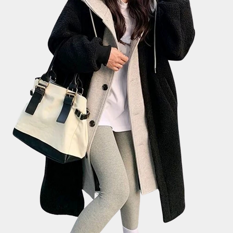 Frau in schwarzem Wollmantel mit beiger Handtasche und grauer Leggings, modisch, winterlich.