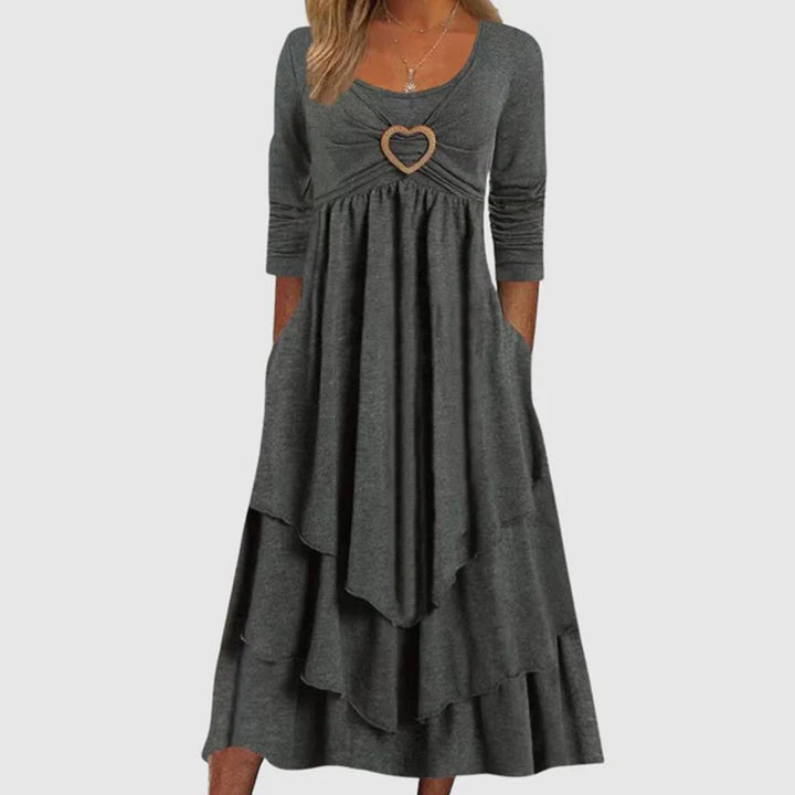 Dunkelgraues Damenkleid mit Herzdetail, langärmelig, knielang, elegantes Design.