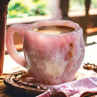 Rosa Kristallkaffeetasse mit heißem Getränk auf Holztisch, ideal für stilvolle Kaffeepausen.