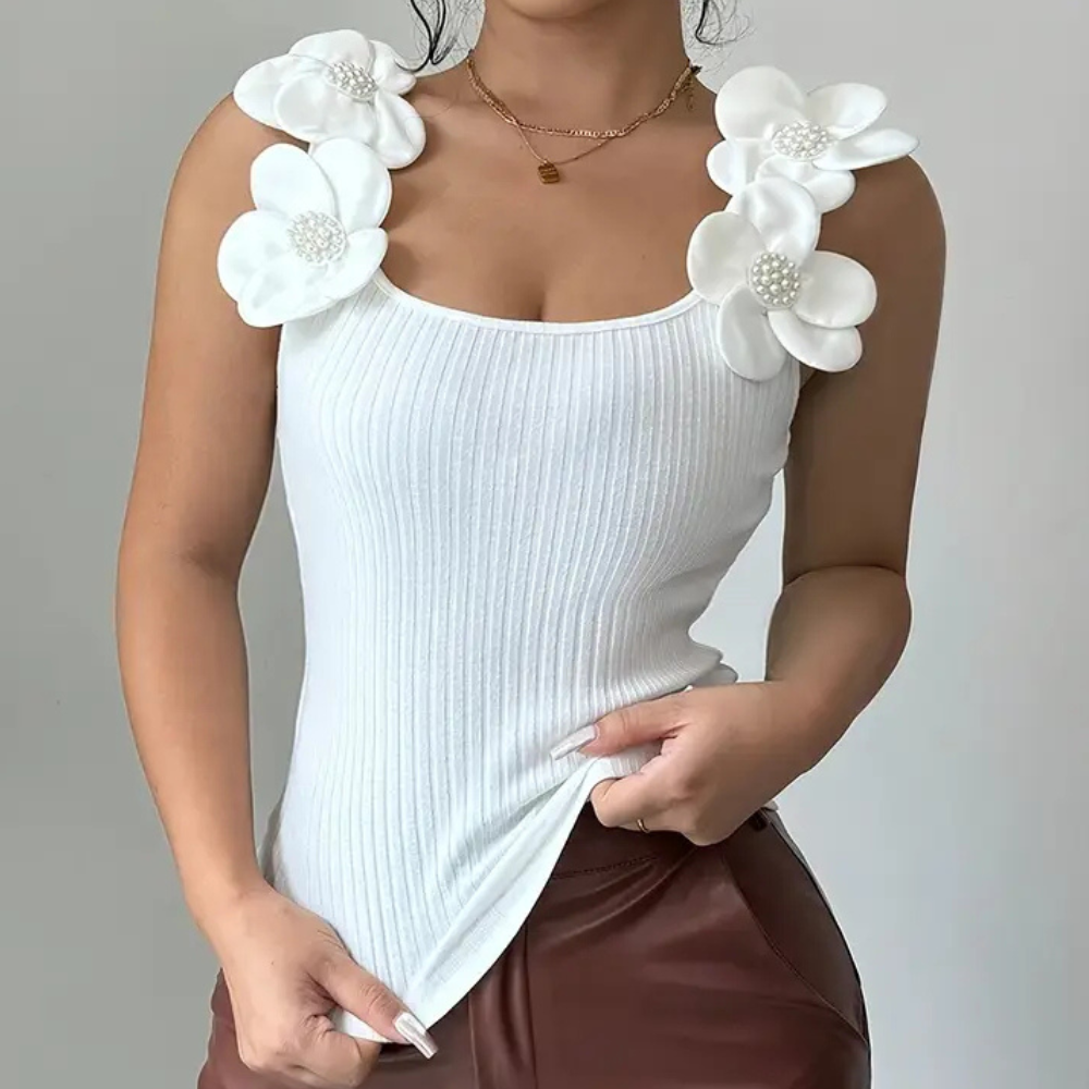Frau in weißem, geripptem Top mit Blumenapplikationen, modisch, elegant, Damenmode.