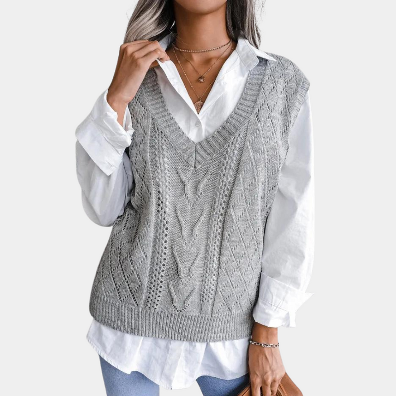 Grauer Strickpullover Damen, V-Ausschnitt, Zopfmuster, über weißer Bluse, modisch, elegant.