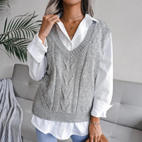 Frau trägt grauen Strickpullover über weißer Bluse, modisch, elegant, Herbstmode.