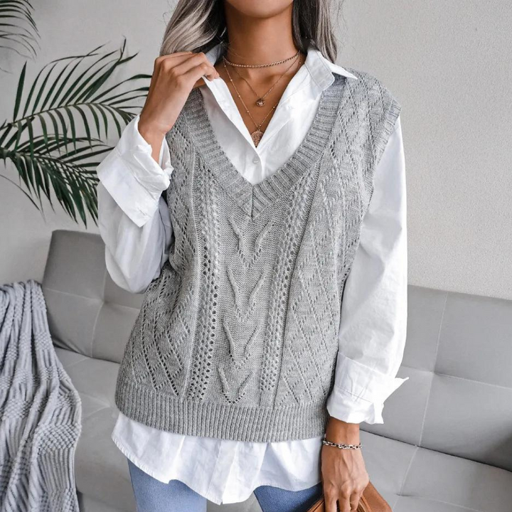 Frau trägt grauen Strickpullover über weißer Bluse, modisch, elegant, Herbstmode.
