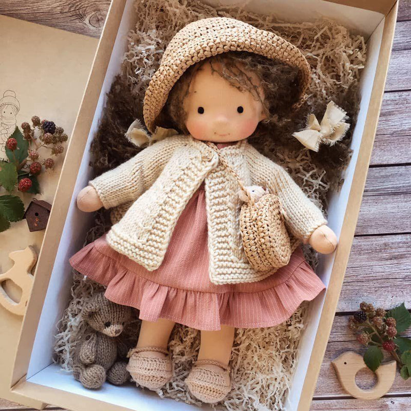 Puppe mit Strohhut, gehäkelter Tasche, Strickjacke und rosa Rüschenkleid im Karton, dazu ein kleiner Bär 7