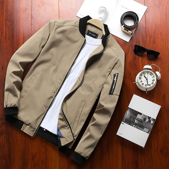 Beige Herren-Sommerjacke, stilvoll, kurz, mit Reißverschluss, auf Holztisch.