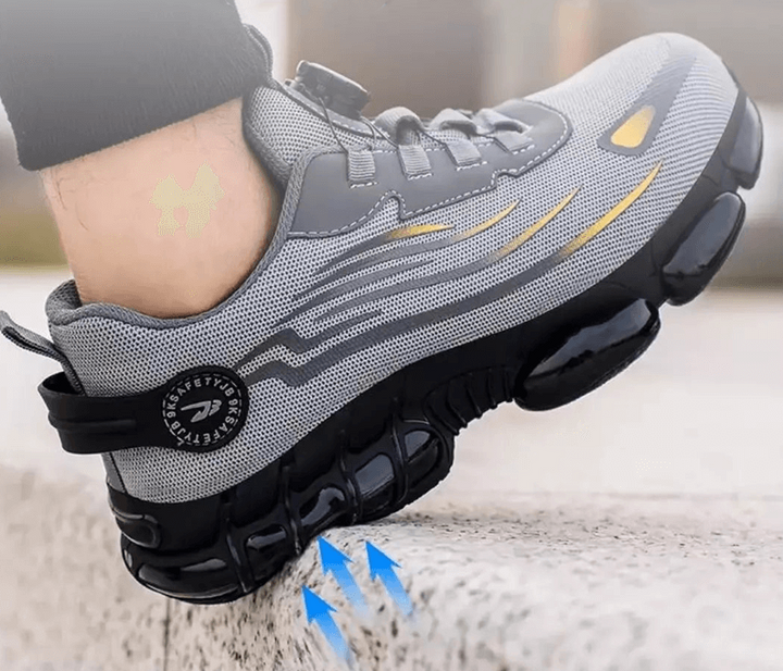 Fuß im grauen Schuh tritt auf eine Steinkante, blaue Pfeile zeigen die Dämpfung der Sohle 7