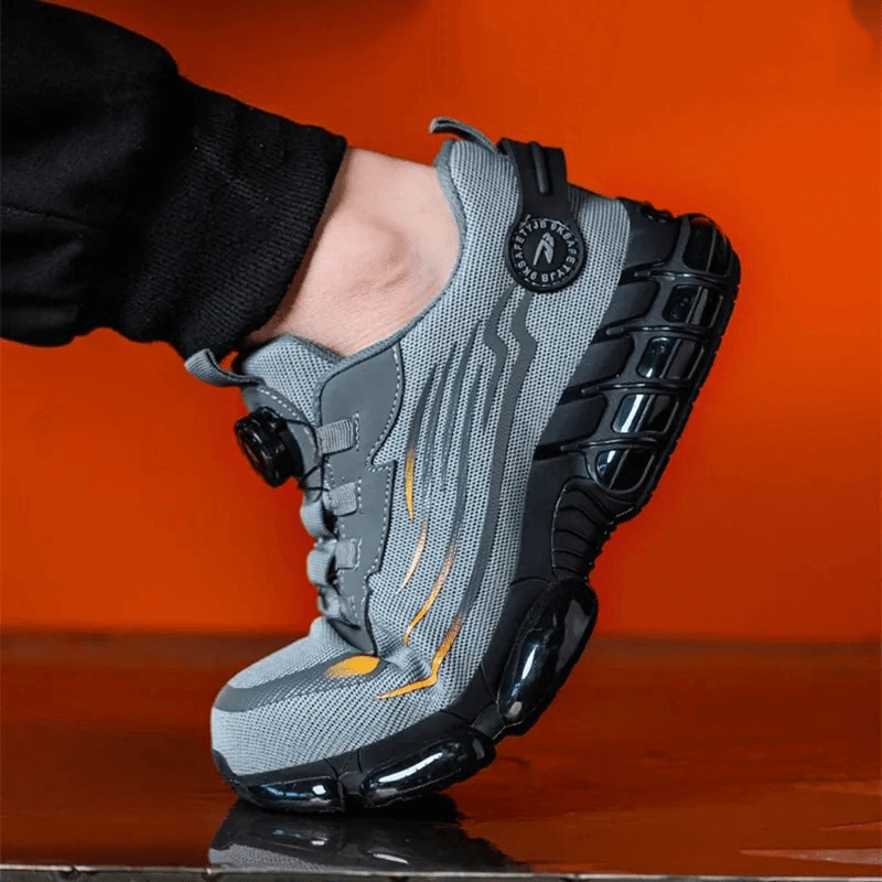 Seitlich fotografierter grauer Schuh am Fuß, die Ferse abgehoben, vor leuchtend orangem Hintergrund 9