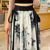 Frau trägt schwarz-weiße Hose mit Bambusmuster, elastischer Bund, modisch, asiatischer Stil.